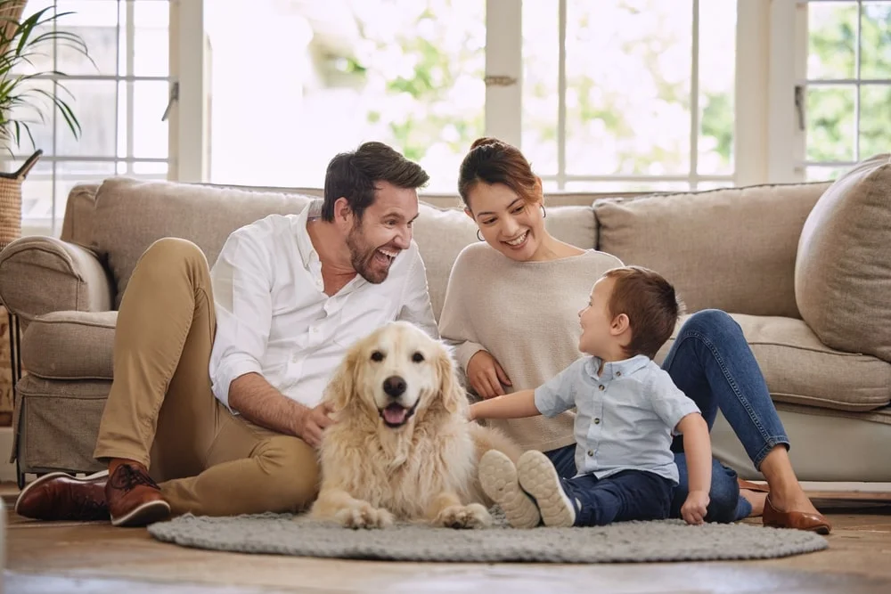 Family lying in the living room with their dog