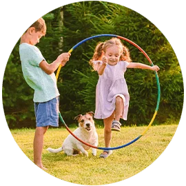 Little girl jumping through a hoop with a dog