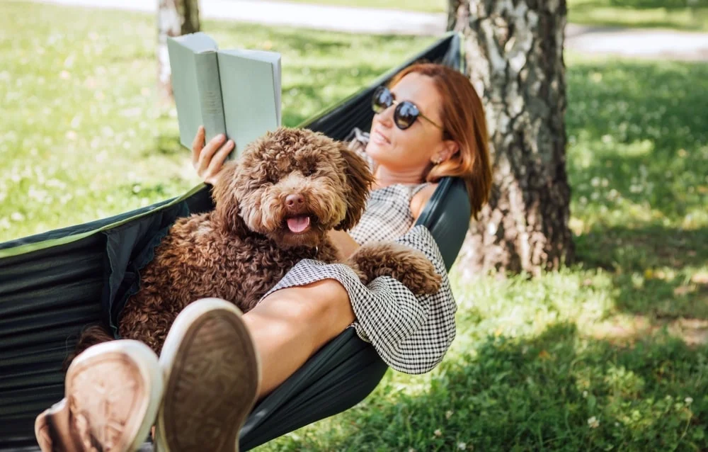 Woman reading a book with a dog