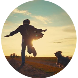 kid running through a field with his pet